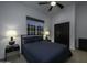 Comfortable bedroom with a ceiling fan, window, and dark blue bedding at 10040 N 78Th Pl, Scottsdale, AZ 85258