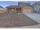 Two-story house with a brown exterior, a two-car garage, and a rock landscaping at 12517 W Rosewood Dr, El Mirage, AZ 85335