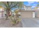 Two-story house with tan exterior, two-car garage, and desert landscaping at 13638 W Desert Flower Dr, Goodyear, AZ 85395
