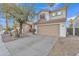 Two-story house with tan exterior, two-car garage, and landscaped front yard at 13638 W Desert Flower Dr, Goodyear, AZ 85395