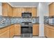 Modern kitchen with granite counters and wood cabinets at 13638 W Desert Flower Dr, Goodyear, AZ 85395