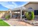 A well landscaped backyard includes trimmed bushes, rock ground cover and a covered outdoor space at 17202 N Javelina Dr, Surprise, AZ 85374
