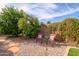 A backyard area with rock ground cover features two chairs and greenery around the perimeter for privacy at 17202 N Javelina Dr, Surprise, AZ 85374