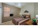 Comfortable bedroom with a colorful striped bedspread, window, and ceiling fan at 17202 N Javelina Dr, Surprise, AZ 85374