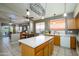 Open kitchen featuring a central island, wood cabinets, and a view to the adjacent dining area at 17202 N Javelina Dr, Surprise, AZ 85374