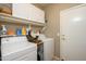 Practical laundry room equipped with washer, dryer, shelving, and storage cabinets at 17202 N Javelina Dr, Surprise, AZ 85374