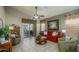 Comfortable living room featuring a red sofa, patterned curtains, and access to a covered patio at 17202 N Javelina Dr, Surprise, AZ 85374