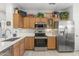 Modern kitchen with wood cabinets and stainless steel appliances at 19043 N Aztec Point Dr, Surprise, AZ 85387
