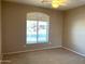 Neutral bedroom with a ceiling fan and a large window for plenty of natural light at 2335 W Muirfield Dr, Anthem, AZ 85086