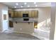 Bright kitchen features wood cabinetry, an eat-in island, tile floors, and sleek black appliances at 2335 W Muirfield Dr, Anthem, AZ 85086