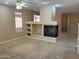 Bright living room featuring a cozy fireplace, built-in shelving, ceiling fan and a neutral color palette at 2335 W Muirfield Dr, Anthem, AZ 85086