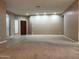 Spacious living room featuring neutral paint, carpet flooring, ample natural light, and a welcoming front door at 2335 W Muirfield Dr, Anthem, AZ 85086
