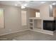 Cozy living room with a fireplace, built-in shelving, ceiling fan and large windows offering natural light at 2335 W Muirfield Dr, Anthem, AZ 85086