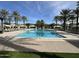 Large, inviting community pool with plenty of lounge chairs and palm tree landscaping at 25311 N 19Th Ln, Phoenix, AZ 85085