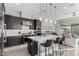 A modern kitchen boasts sleek, dark cabinetry, stainless steel appliances, and a large island with stylish pendant lighting at 25311 N 19Th Ln, Phoenix, AZ 85085