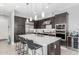 The kitchen features modern dark cabinets, a stainless steel fridge, and a large center island with a sink at 25311 N 19Th Ln, Phoenix, AZ 85085