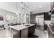 The modern kitchen features dark cabinets, stainless steel appliances, and an island with barstool seating at 25311 N 19Th Ln, Phoenix, AZ 85085