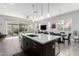 Kitchen island with seating, stainless steel sink, and views of the adjacent living and dining areas at 25311 N 19Th Ln, Phoenix, AZ 85085
