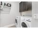 Laundry room featuring a front loading washer and dryer and overhead cabinet at 25311 N 19Th Ln, Phoenix, AZ 85085