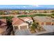 Aerial view of a single-story house with a two-car garage, and a golf course at 27062 W Behrend Dr, Buckeye, AZ 85396