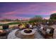 Relaxing backyard patio with fire pit and seating area, offering stunning sunset views at 27062 W Behrend Dr, Buckeye, AZ 85396