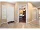 Bright entryway with tile flooring, leading to an office with built-in shelving at 27062 W Behrend Dr, Buckeye, AZ 85396