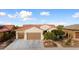 Front view of a house with a brown garage door and desert landscaping at 27062 W Behrend Dr, Buckeye, AZ 85396