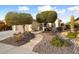 Beautiful desert landscaping surrounds this single-story home with a tan stucco exterior and attached garage at 27062 W Behrend Dr, Buckeye, AZ 85396