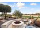 Landscaped patio with fire pit and seating area at 27062 W Behrend Dr, Buckeye, AZ 85396