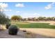 View of a lush green golf course with homes in the background at 27062 W Behrend Dr, Buckeye, AZ 85396