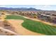 Aerial view of a golf course with surrounding desert landscape and homes at 27062 W Behrend Dr, Buckeye, AZ 85396