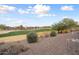 View of a green golf course with surrounding desert landscape at 27062 W Behrend Dr, Buckeye, AZ 85396