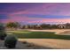 Scenic golf course view at sunset, with homes in the distance at 27062 W Behrend Dr, Buckeye, AZ 85396