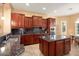Modern kitchen with dark wood cabinets, granite counters, and stainless steel appliances at 27062 W Behrend Dr, Buckeye, AZ 85396