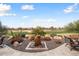 Landscaped backyard with a water feature and golf course view at 27062 W Behrend Dr, Buckeye, AZ 85396