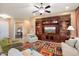 Open living room with built-in shelving and large TV at 27062 W Behrend Dr, Buckeye, AZ 85396