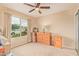 Bedroom with dresser, nightstand, and large window with natural light at 37110 W Leonessa Ave, Maricopa, AZ 85138