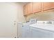 Laundry room with washer, dryer, and upper cabinets at 37110 W Leonessa Ave, Maricopa, AZ 85138