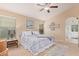 Main bedroom with king-size bed, ensuite bathroom access, and ceiling fan at 37110 W Leonessa Ave, Maricopa, AZ 85138