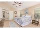 King-size bed in a bright main bedroom with ceiling fan and large windows at 37110 W Leonessa Ave, Maricopa, AZ 85138