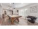 Open game room with a pool table, arcade game, wood look floors, and natural light at 502 E Le Marche Ave, Phoenix, AZ 85022