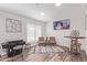 Open concept living room with a game system, bicycle art, and seating area with natural light at 502 E Le Marche Ave, Phoenix, AZ 85022