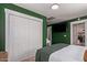 Cozy bedroom with a queen bed and large closet, showcasing a green accent wall at 521 E Lehi Rd, Mesa, AZ 85203