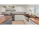 Bright kitchen with white cabinets, a farmhouse sink, and wood countertops at 521 E Lehi Rd, Mesa, AZ 85203