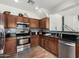 Well-equipped kitchen featuring dark wood cabinets, granite countertops, and stainless steel appliances at 5374 W Chisum Trl, Phoenix, AZ 85083
