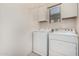 A simple white-walled laundry area with front-load washer and dryer, and cabinets at 5374 W Chisum Trl, Phoenix, AZ 85083