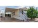 Tan mobile home with covered patio, white railing, and landscaping at 8700 E University Dr # 1315, Mesa, AZ 85207