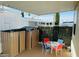 Enclosed patio area featuring a dining set, storage sheds, and a privacy wall of lush greenery at 8700 E University Dr # 1315, Mesa, AZ 85207