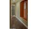Hallway with hardwood floors and a decorative alcove shelf, leading to a paneled door at 9441 E Juanita Ave, Mesa, AZ 85209