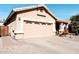 Tan house with a two-car garage and desert landscaping at 968 W Breckenridge Ave, Gilbert, AZ 85233